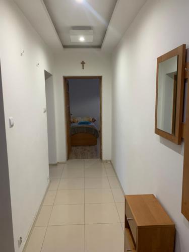 a hallway with a room with a bed and a mirror at APARTAMENT NAD JEZIORKIEM KĘTRZYŃSKIM in Kętrzyn
