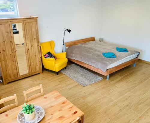 a bedroom with a bed and a table and a yellow chair at Ferienwohnung in Albstadt