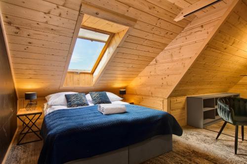 a bedroom with a bed in a wooden attic at Willa Królewska - Wellness SPA - widokowe Pokoje i Apartamenty in Kościelisko