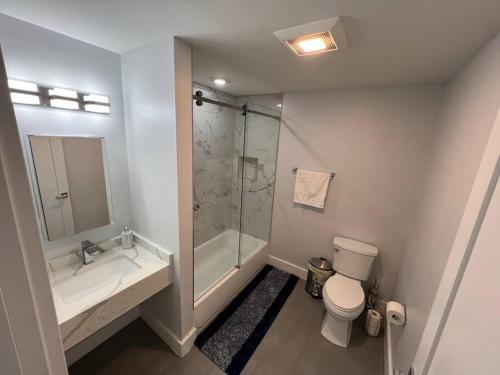a bathroom with a shower and a toilet and a sink at The Chic Suite - 1BR with Luxe Amenities in Paterson