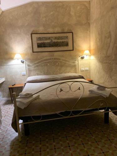 a bed in a room with two lamps on the wall at Villa Giovanna Citylife Milano in Milan