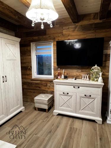 a living room with a television and a white cabinet at oBłędne Chaty in Wünschelburg