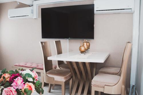 uma sala de jantar com mesa e cadeiras e uma televisão em SU APARTAMENTO NEIVA CON AIRE Acondicionado em Neiva