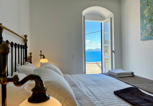 a bedroom with a bed with a view of the ocean at Villa Sunset Signature - Private Pool & Sea View in Hydra