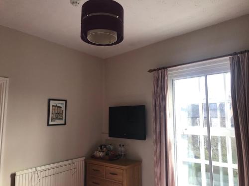 a living room with a television and a window at The Apple House in York