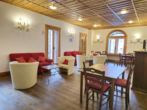 ein Wohnzimmer mit einem Sofa, Tischen und Stühlen in der Unterkunft Appartamento del Re e della Regina in Ceresole Reale