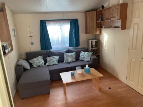 un salon avec un canapé et une table dans l'établissement mobil loc a la semaine, à Portbail