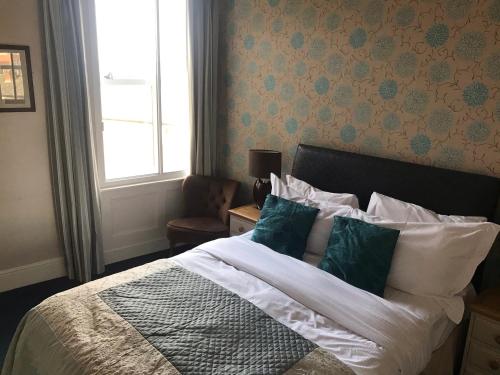 a bedroom with a bed with pillows and a window at The Apple House in York