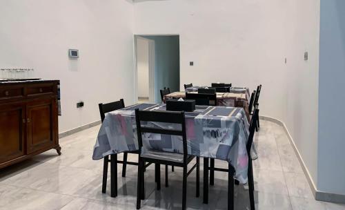 un comedor con una mesa con sillas cubiertas de plástico en Cony’s Guest House, en Kwabenyan
