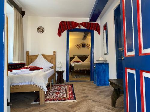 a bedroom with a bed and a blue door at Casa Soarelui in Murighiol
