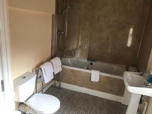a bathroom with a tub and a toilet and a sink at The Apple House in York