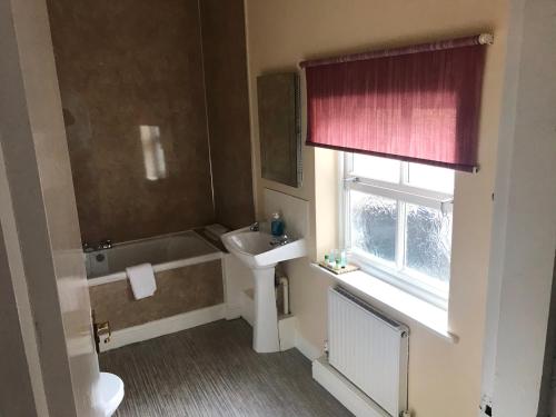 a bathroom with a sink and a bath tub at The Apple House in York
