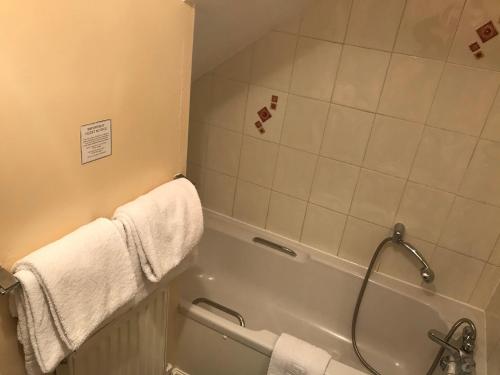 a bathroom with a shower and a tub with towels at The Apple House in York