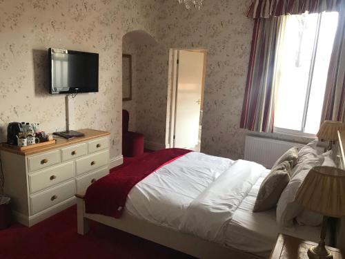 a bedroom with a bed and a television on a dresser at The Apple House in York