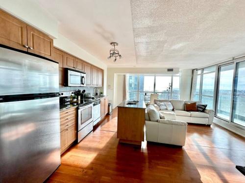 a kitchen with a living room with a couch at Lake View Apartment w/Parking! in Toronto