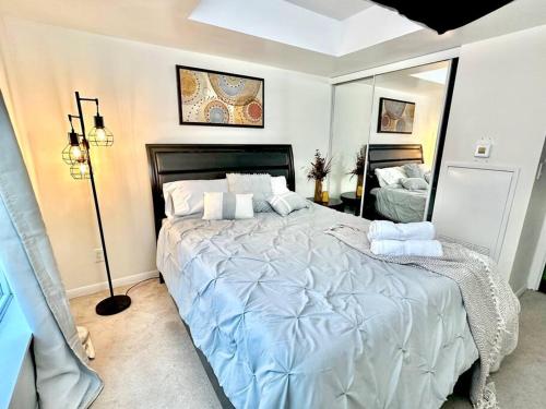 a bedroom with a large bed and a mirror at Lake View Apartment w/Parking! in Toronto