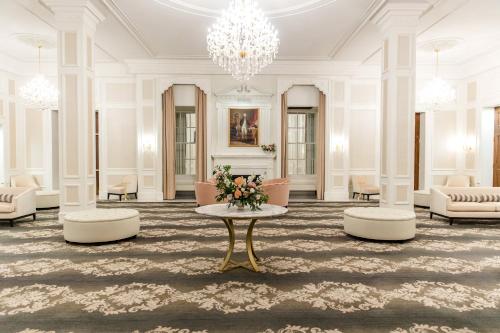 a lobby with a table and chairs and a chandelier at The Lord Nelson Hotel & Suites in Halifax