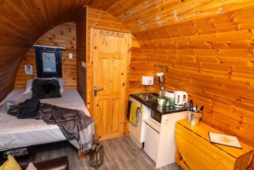 una camera con un letto in una cabina di legno di The Arns Glamping Pods a Bridge of Allan