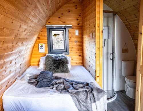 a bedroom with a bed in a wooden cabin at The Arns Glamping Pods in Bridge of Allan