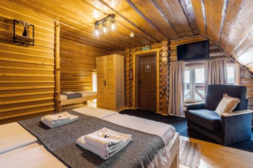 a bedroom with a bed and a chair in a room at Gremi Hotel in Dragobrat