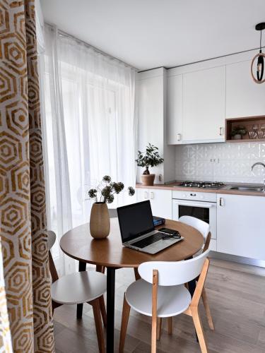 een keuken met een tafel en een laptop bij City of Mara Central Apartment in Timişoara