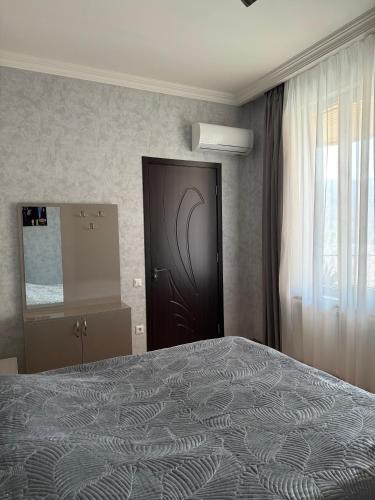 a bedroom with a large bed and a door at guest house TMT in Sighnaghi
