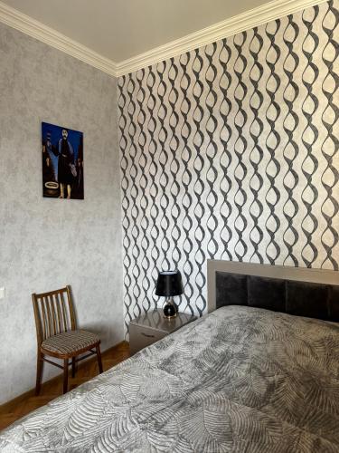 a bedroom with a bed and a wall with a wallpaper at guest house TMT in Sighnaghi