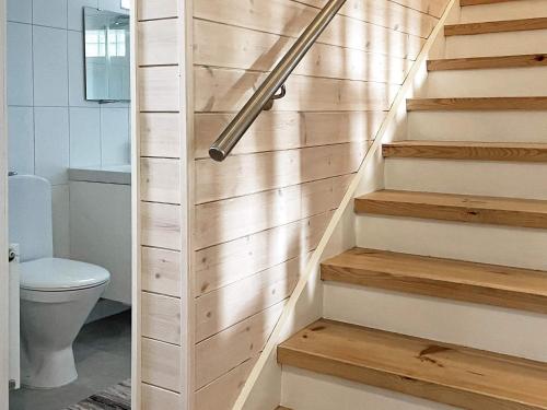 a bathroom with a toilet and wooden stairs at Holiday home HENÅN VIII in Henån