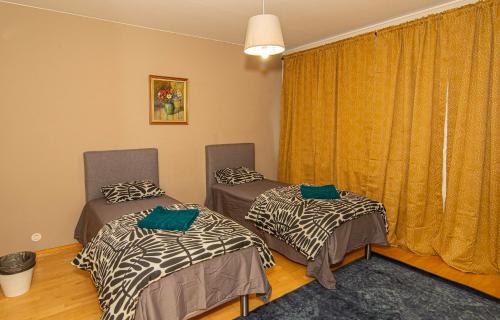 two twin beds in a room with a window at 2-Bedroom Apartment in Heart of City Center in Turku