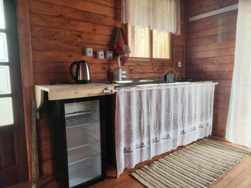 a kitchen with a counter and a sink in a room at Chalé Eco Camping Kazeando Pelo Mundo in Urupema