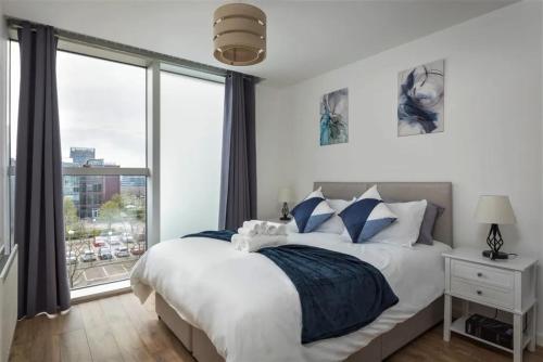 a bedroom with a bed and a large window at Luxury Milton Keynes Apartment at The Prevé in Milton Keynes