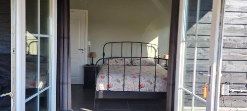 a bedroom with a bed with a floral bedspread at wellness chalet met jacuzzi, sauna, omheinde tuin, in Sint Annaland