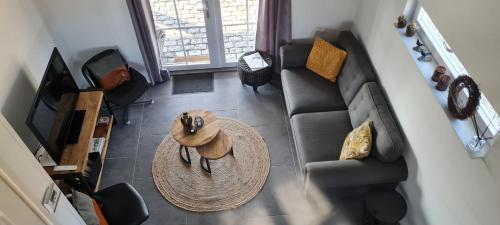 an overhead view of a living room with a couch and a table at wellness chalet met jacuzzi, sauna, omheinde tuin, in Sint Annaland