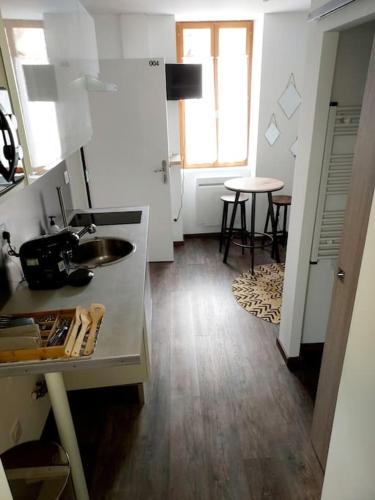 uma cozinha com um lavatório e uma mesa num quarto em T2 cosy vieux Montluçon em Montluçon