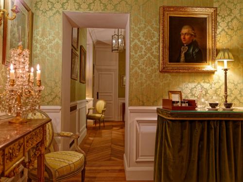 a room with a painting of a man on the wall at Relais & Château Louise de La Vallière in Reugny