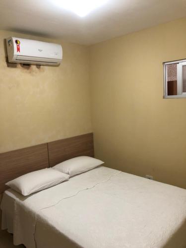 a bedroom with a bed with a air conditioner on the wall at Casa Costa do Mar - Pé na areia em Maragogi in Maragogi