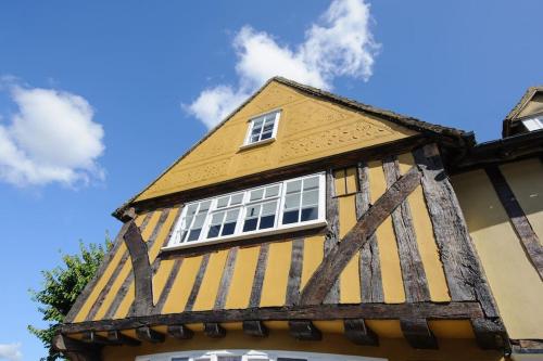 a yellow and white building with white windows at The Famous Harry Potter House in Saffron Walden