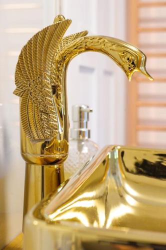 a bathroom sink with a gold faucet on it at The Famous Harry Potter House, Hot Tub, Cinema Room, Sky TV in Saffron Walden