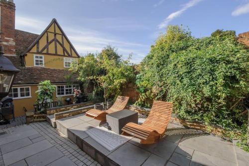 three chairs sitting on a patio in front of a house at The Famous Harry Potter House, Hot Tub, Cinema Room, Sky TV in Saffron Walden
