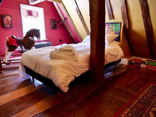 a bedroom with a bed with a dog standing on it at The Famous Harry Potter House, Hot Tub, Cinema Room, Sky TV in Saffron Walden