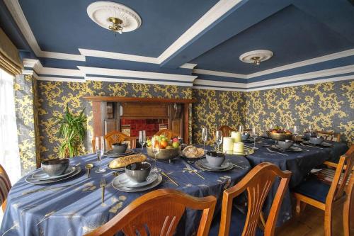 a dining room with a blue table with food on it at The Famous Harry Potter House, Hot Tub, Cinema Room, Sky TV in Saffron Walden