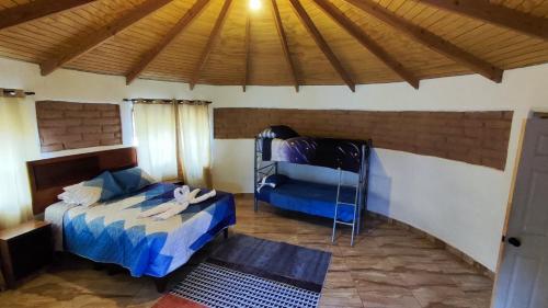 1 dormitorio con cama y techo de madera en cabañas katchi en San Pedro de Atacama