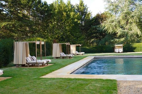 Reugny的住宿－Relais & Château Louise de La Vallière，后院设有带椅子的游泳池和帐篷