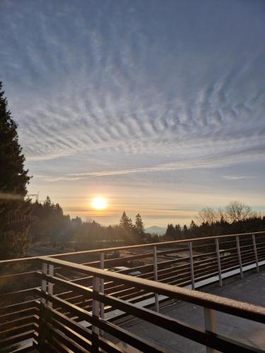 a view of the sunset from a bridge with a fence at Appartement au pied des pistes avec grande terrasse in Orbey