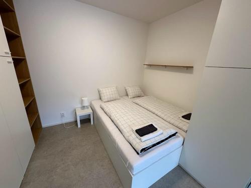 a small bedroom with a bed with a laptop on it at Bella Apartments Brno in Brno