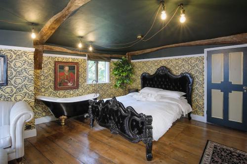 1 dormitorio con 1 cama grande y bañera en Versace 2 Bed Manor House With Hot Tub, en Saffron Walden