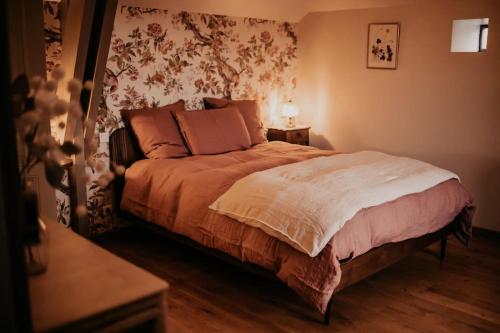 a bedroom with a bed with a floral wallpaper at Maisonnette de charme Les Jardins de Lou in Boussac