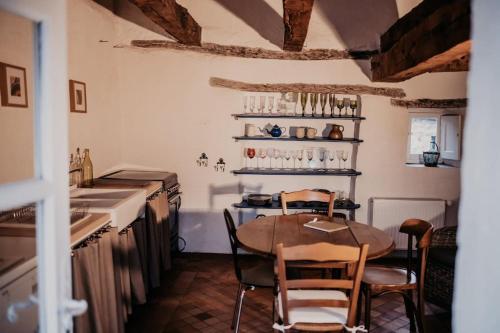 a kitchen with a table and chairs in a room at Maisonnette de charme Les Jardins de Lou in Boussac