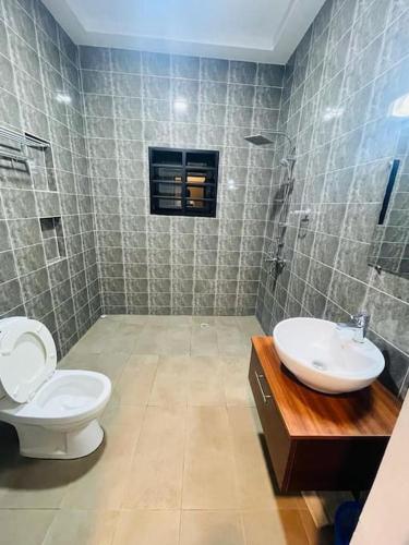 a bathroom with a toilet and a sink at Serenity Haven:Your Ideal Escape in Lomé