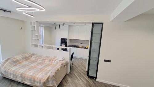 a bedroom with a bed and a kitchen at AIRPORT 24&24 CAR PARKING in Chişinău